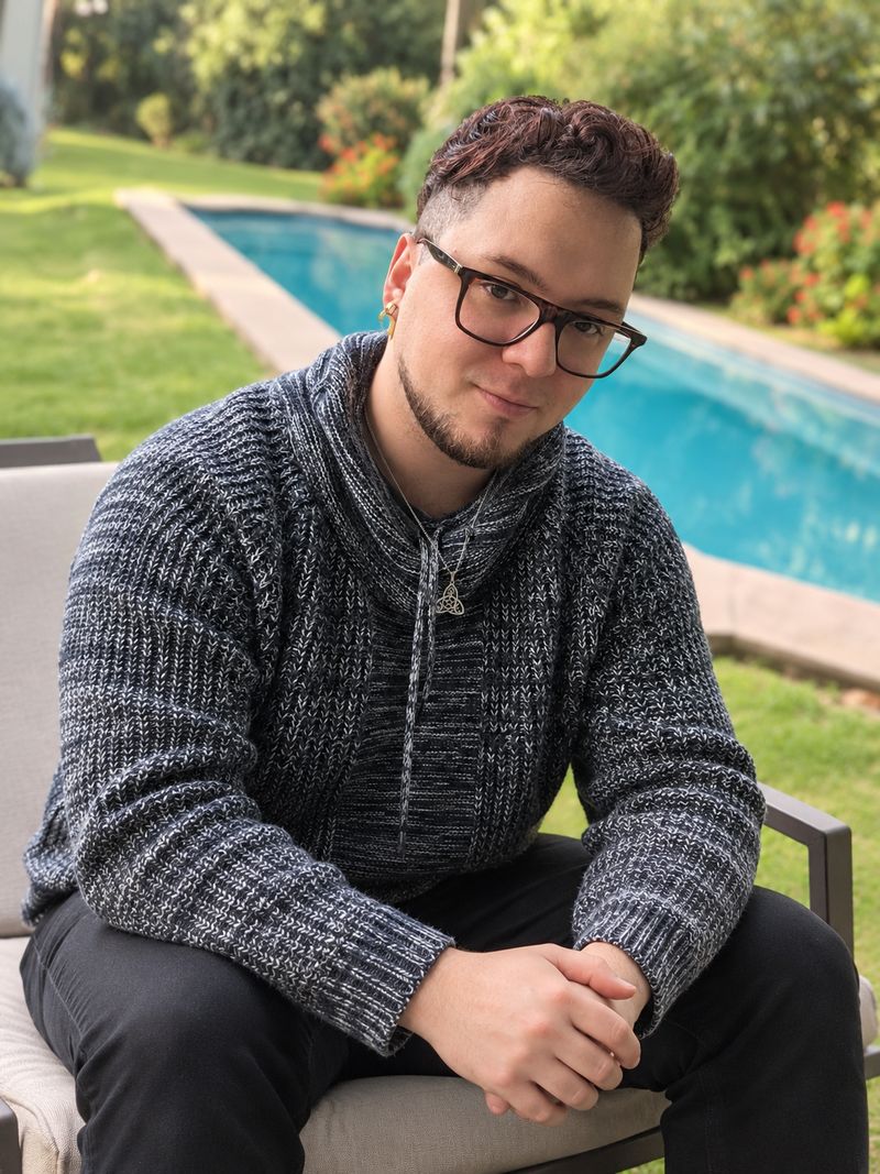 Iván Oda sentado en un jardín junto a una piscina