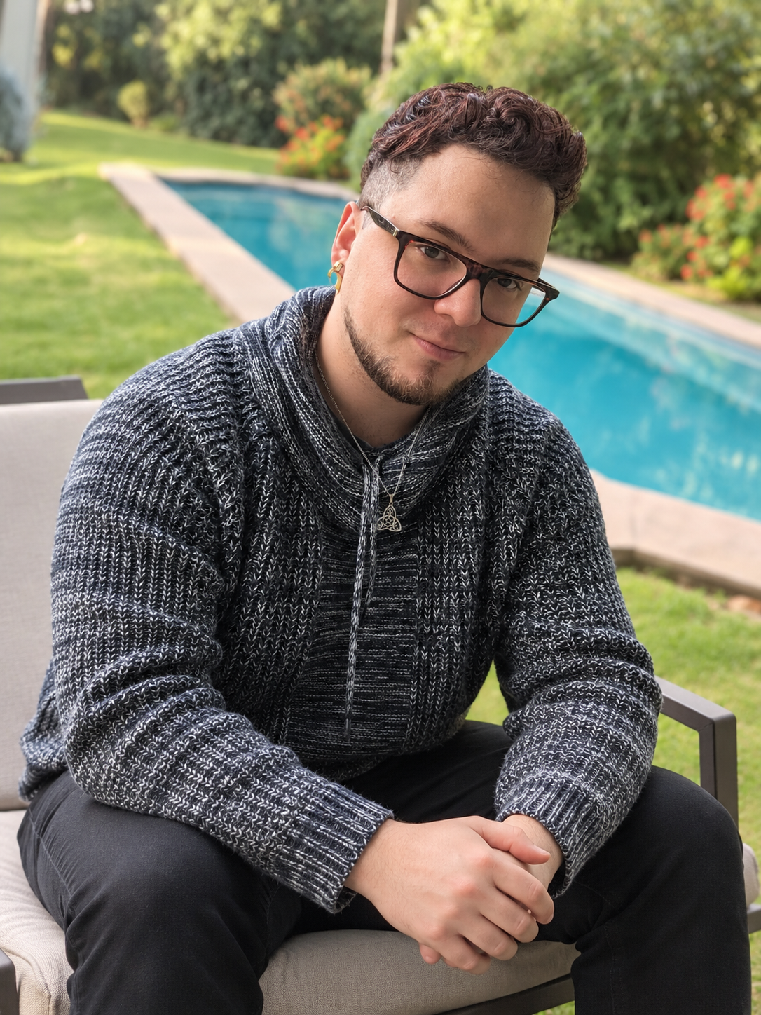 Iván Oda sentado en un jardín junto a una piscina